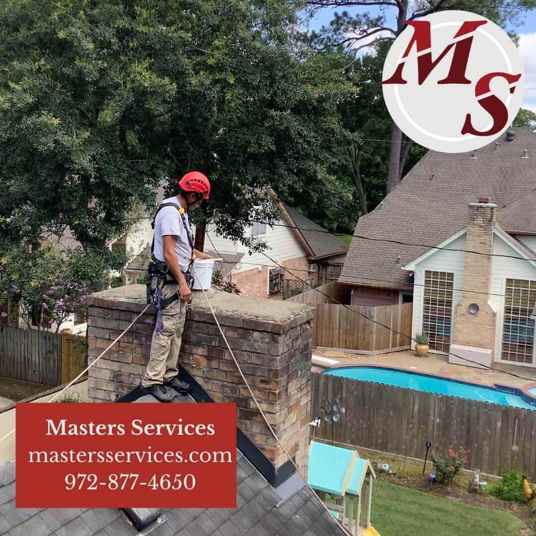 Technician on top of roof repairing masonry chimney. - Chimney Repair Dallas - Dallas, TX - Masters Services Chimney & Masonry